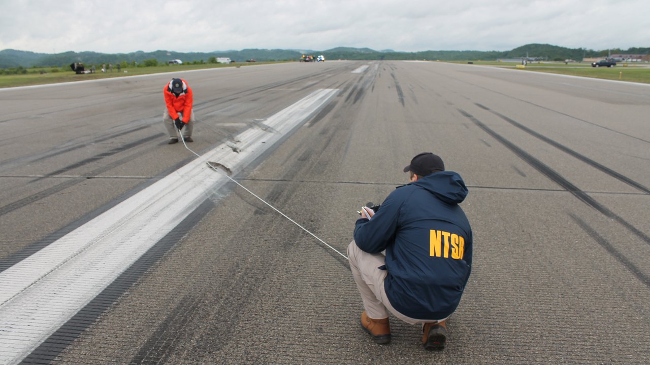 NTSB investigators document marks on the runway at Yeager Airport.